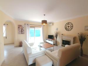 een woonkamer met witte meubels en een open haard bij OASIS Luxury Villa Portimao in Portimão