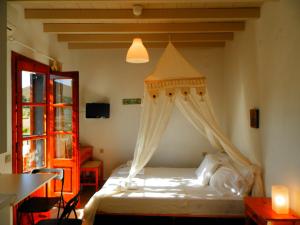 a bedroom with a bed with a canopy and a window at Filio Apartments in Kámbos