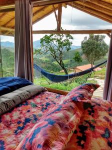 a bed in a room with a large window at Recanto das Estrelas in Aiuruoca