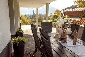 een tafel met een vaas met bloemen op een veranda bij Ferienwohnung Aichner in Mittersill