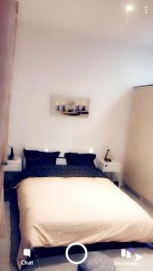 a bedroom with a large bed with two tables at Eyssam d’or in Dijon