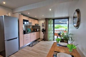 Una cocina con refrigerador y una mesa en una habitación. en la rose, en Lamentin