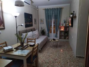 ein Wohnzimmer mit einem Sofa und einem Tisch in der Unterkunft Apartamento Duque de Arcos in Arcos de la Frontera