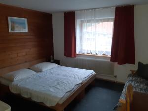 a bedroom with a bed and a window at Haus Bergfrieden in Achenkirch +4 photos