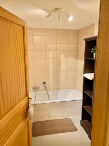 uma casa de banho com banheira e chuveiro em Gite "La Maison Jaune" à Kaysersberg avec garage em Kaysersberg
