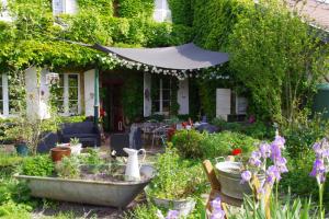 un jardín con flores y plantas frente a una casa en Chambres d'hôtes Au presbytère, en Racrange