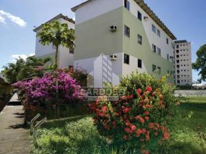 a white building with flowers in front of it at Mar Azul Condomínio in Aracaju