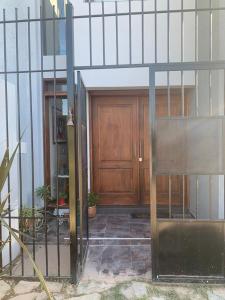 een toegang tot een gebouw met een houten deur bij departamento confortable in Ciudad Lujan de Cuyo