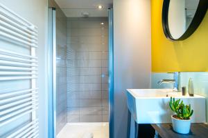 W łazience znajduje się umywalka i prysznic. w obiekcie The Originals Boutique Hotel Saint James, Montaigu-Vendée, Nantes Sud w mieście Montaigu-Vendée