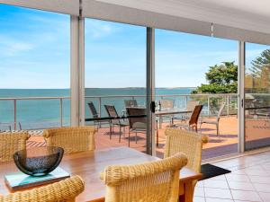 a dining room with a view of the ocean at Beachfront Penthouse Cowes in Cowes