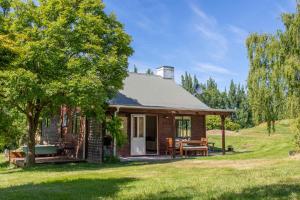 a log cabin with a picnic table in a field at Arrowtown Country Cottage in Arrowtown