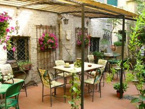 eine Außenterrasse mit einem Tisch und Stühlen in der Unterkunft Locanda Borgonuovo in Ferrara