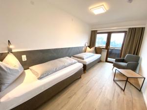 uma sala de estar com um sofá grande e uma cadeira em Appartement Haus Seerose em Reith im Alpbachtal