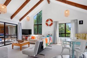 a living room with a table and a couch at Coastal Charm - Waihi Beach Holiday Home in Waihi Beach