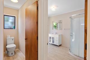 a bathroom with a toilet and a shower at Coastal Charm - Waihi Beach Holiday Home in Waihi Beach +16 photos