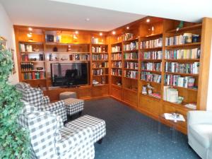 a library with couches and shelves of books at Haus Köbesine in Juist