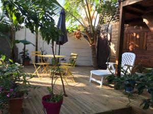 un patio con sillas, una mesa y una sombrilla en Chambre1 Résidence Beauregard, en Koungou