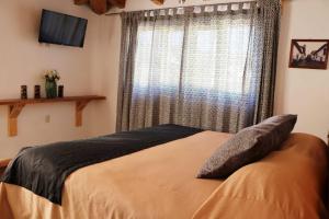 - une chambre avec un grand lit et une fenêtre dans l'établissement Hotel Bugamvillas Tapalpa extensión, à Tapalpa