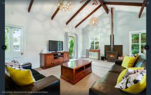 Central Peach - Queenstown Holiday Home في كوينزتاون: غرفة معيشة مع أريكة وتلفزيون