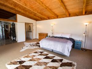 a bedroom with a bed and a wooden ceiling at Mohua - Pakawau Holiday Home in Pakawau