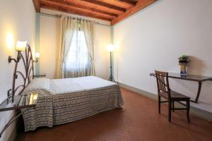 1 dormitorio con cama, mesa y ventana en Antico Pastificio, en Greve in Chianti