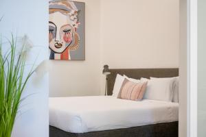 a bedroom with a white bed and white walls at Terminus Apartment Hotel Newcastle in Newcastle