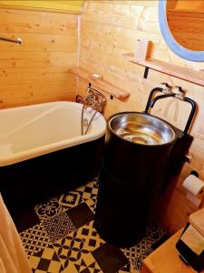 a bathroom with a bath tub and a bath tub at La Maison des Oiseaux. Roulotte in Achicourt