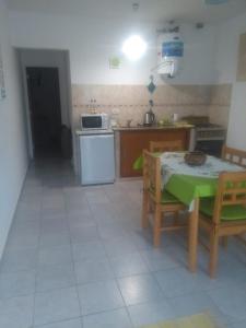 uma cozinha com uma mesa e uma cozinha com um fogão em Miró departamento con cochera em Villa María