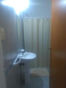 uma casa de banho com um lavatório e um chuveiro com um espelho. em Miró departamento con cochera em Villa María