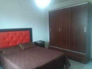 um quarto com uma cama e um grande armário de madeira em Miró departamento con cochera em Villa María
