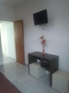 um quarto com uma mesa e uma televisão na parede em Miró departamento con cochera em Villa María