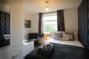 a bedroom with a large bed with a window at Canterbury Comfy 6 Bed House with Hot Tub - Entire House in Canterbury