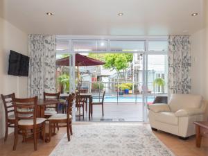 a living room with a table and chairs and a large window at Commodores Lodge in Russell