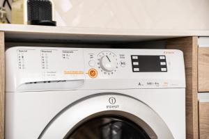 a white washing machine in a laundry room at Bracara Guest House "Campo das Hortas" in Braga