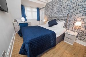G Boutique Hotel في بورتسماوث: غرفة نوم مع سرير وبطانية زرقاء