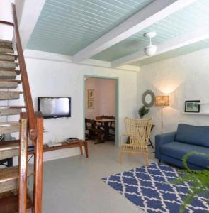 a living room with a blue couch and a table at Casa Boutique Peró in Cabo Frio