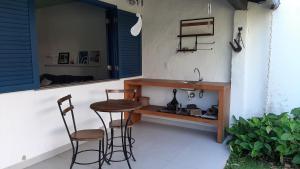 a patio with two chairs and a sink and a counter at Casa Boutique Peró in Cabo Frio