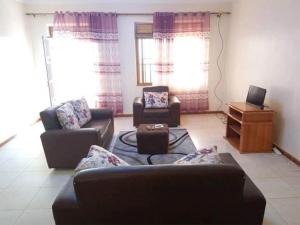 ein Wohnzimmer mit zwei Sofas und einem Fernseher in der Unterkunft Apartment in the city of Kampala in Kampala