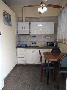 a kitchen with white cabinets and a table with chairs at Alto Unimev in Mendoza