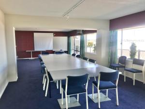 uma sala de conferências com uma grande mesa e cadeiras em Tui Oaks Motel em Taupo