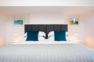 una camera da letto con un letto grande con cuscini blu di Clifton Jewel - 4 bed townhouse with parking. MyCityHaven a Bristol