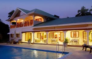 a house with a swimming pool in front of it at Villa De Cerf in Cerf Island