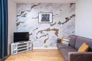 a living room with a couch and a wall mural at Clifton Jewel - 4 bed townhouse with parking. MyCityHaven in Bristol