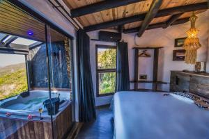 1 dormitorio con bañera, cama y ventana en Villa Buena Vista, en Praia do Rosa