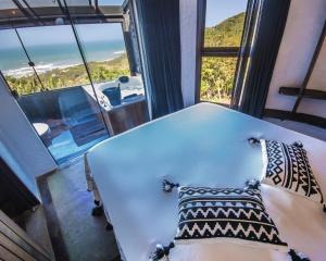 a room with a bed and a large window at Villa Buena Vista in Praia do Rosa