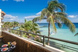 a balcony with a table with food and a view of the ocean at Ocean Plaza by Zamá Homes in Playa del Carmen