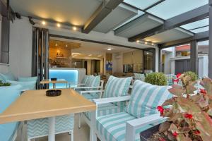 eine Terrasse mit blau-weißen Stühlen und einem Tisch in der Unterkunft Alarzo Rooms in Paralia Katerinis