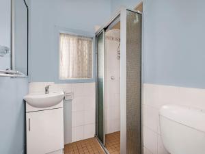 Un baño con ducha, lavabo e inodoro. en Hutton Hide Away, en The Entrance