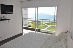 1 dormitorio con cama y vistas al océano en Departamento con Vista al Mar- Condominio Nautico Las Velas en Paracas