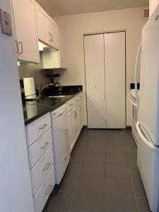 uma cozinha com armários brancos e um frigorífico branco em WaterSide Boston 30 Day Stays em Boston